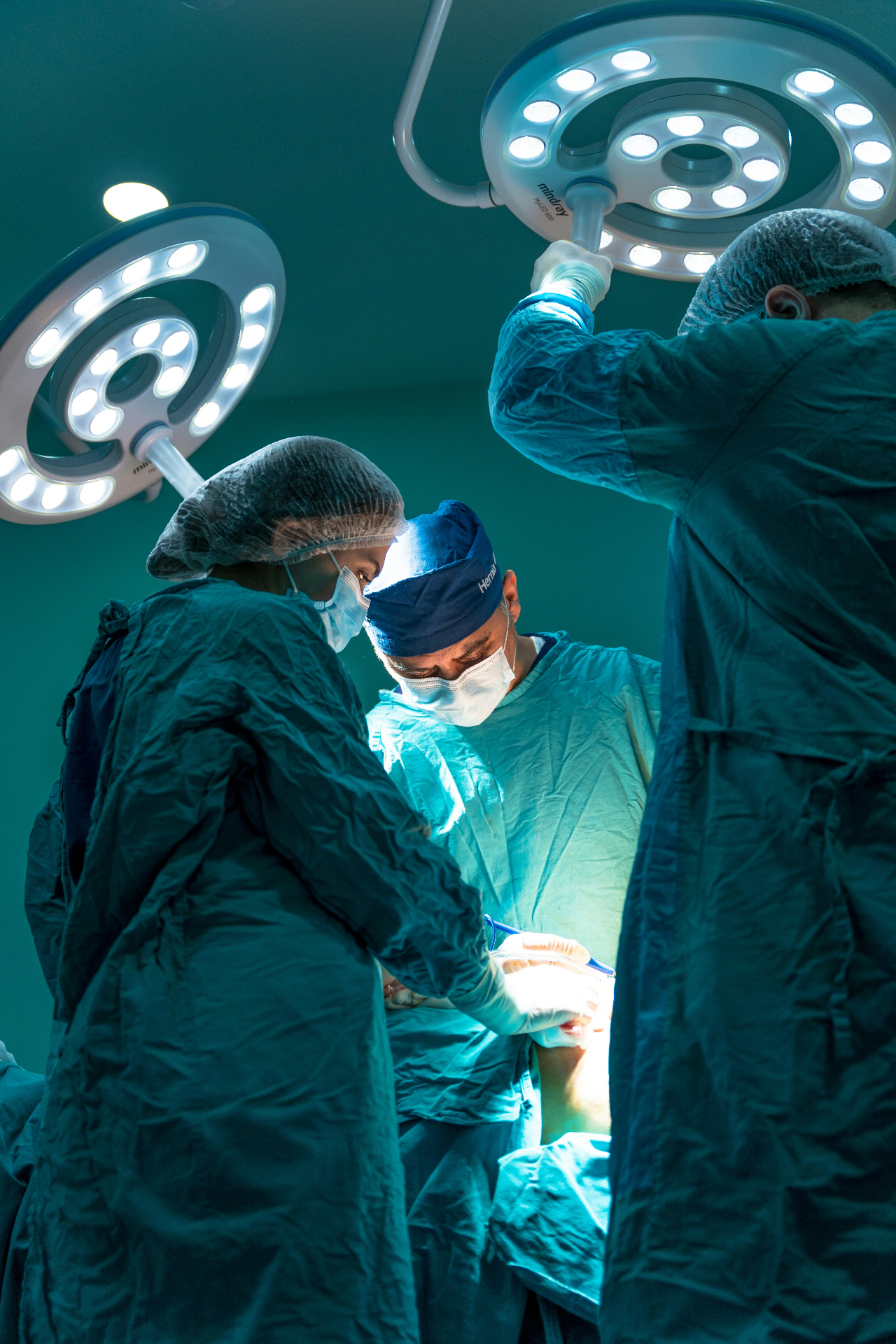 Surgeons performing a live operation under OR lights